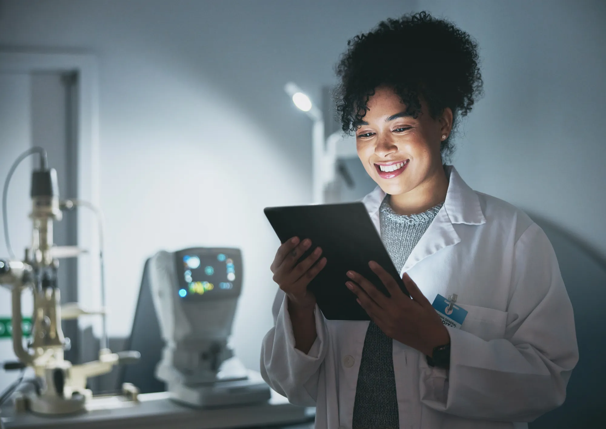 Médica sorrindo enquanto consulta um tablet